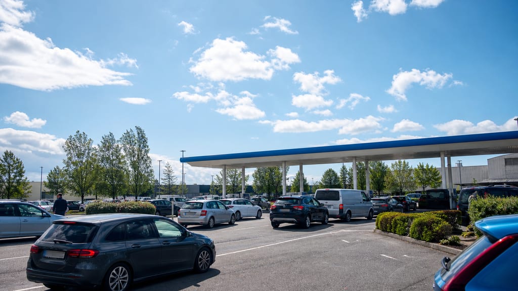 File discrète à une station d’hypermarché le week-end en France, auvent et parking — prix carburant Super U — Cours de la Portelle à Montluel en grande surface
