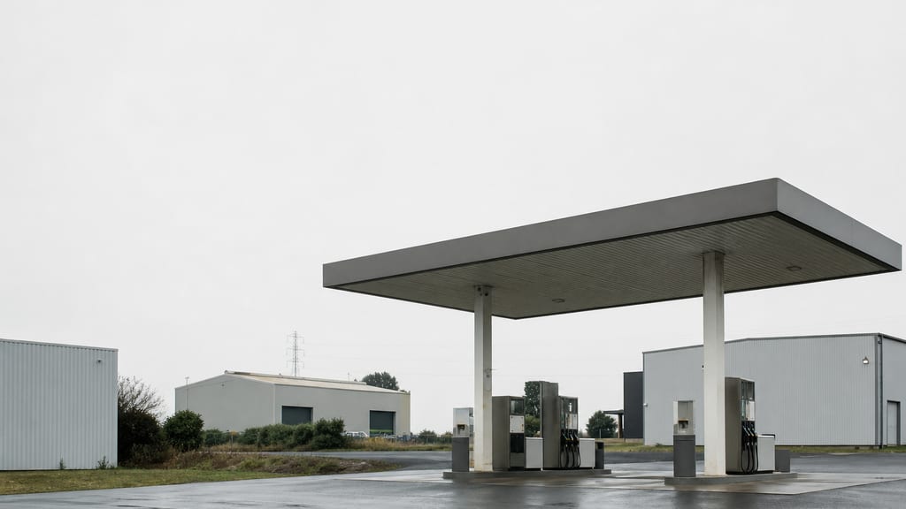 Station-service en zone d’activité périurbaine française, entrepôts flous derrière — prix carburant TotalEnergies — Boulevard de Troyes à Talant en ville