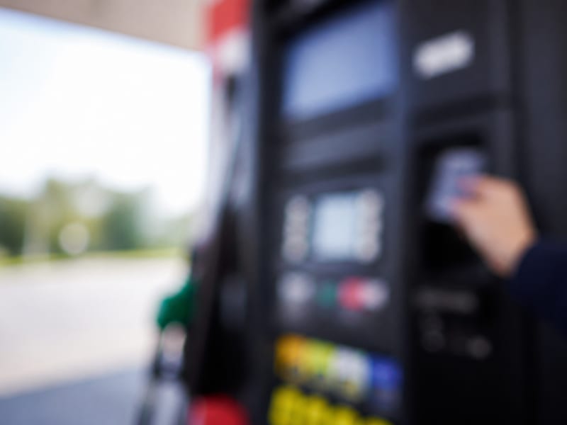 Terminal de paiement flou près d’une pompe à carburant en France — prix carburant TotalEnergies — Route de Dijon à Ville Sous la Ferte